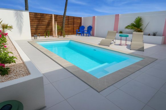 Private turquoise pool with sun loungers and tropical décor at Villa Sunset in Aruba.