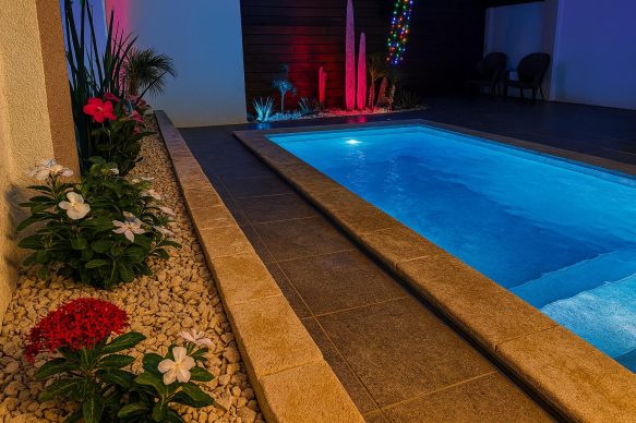 Luxury private pool at Villa Sunset in Aruba illuminated at night with tropical garden lighting, perfect for couples on an adults-only getaway.