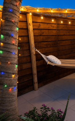 Private Hammock & Tropical Courtyard | Flamingo Bay Villas Aruba Private tropical hammock at Flamingo Bay Villas in Savaneta, Aruba, with ambient evening lighting and a peaceful outdoor relaxation area.