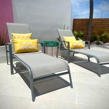 Poolside loungers with yellow cushions at Villa Sunrise, Flamingo Bay Villas in Aruba.