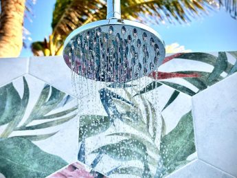 Outdoor shower with tropical floral tiles at Villa Sunrise, Flamingo Bay Villas Aruba.