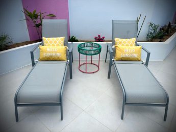Poolside loungers with yellow cushions at Villa Sunrise, Flamingo Bay Villas in Aruba.