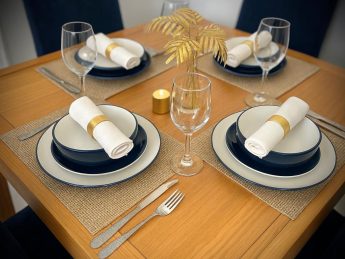 Elegant dining table set for four with modern tableware at Villa Sunrise, Flamingo Bay Villas Aruba.