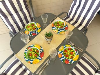 Outdoor dining table set with colorful salads at Villa Sunrise, Flamingo Bay Villas Aruba