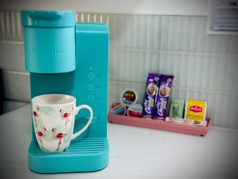 Turquoise Keurig coffee maker with flamingo mug and K-Cup pods at Villa Sunrise, Flamingo Bay Villas Aruba.