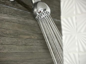 Modern bathroom at Villa Sunrise, Flamingo Bay Villas Aruba with sink, mirror, toilet, and fresh towels.