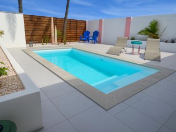 Private turquoise pool with sun loungers and tropical décor at Villa Sunset in Aruba.